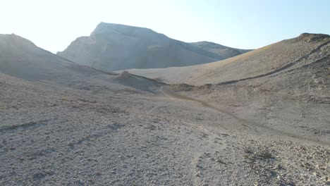 Woman-in-black-walking-on-desert,-life-on-mars-trail,-island-of-Pag,-Croatia