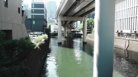 urban canal in japan: cityscape with highway overpass
