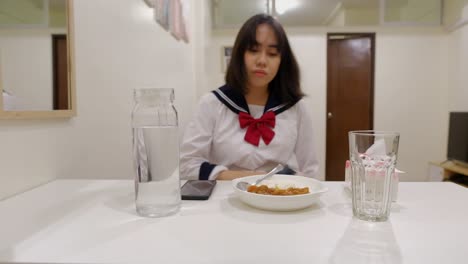 portrait of a teen girl removing apron and eat dinner at home