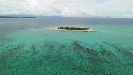 Flying-over-island-in-Fiji-surrounded-by-coral-reef