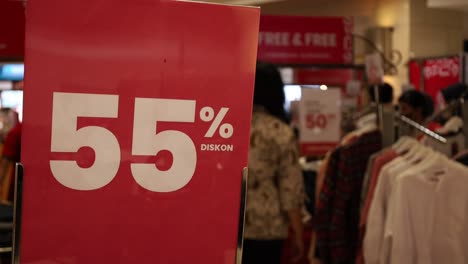 Verkauf-55%-Rabattschild-Mit-Einkaufsleuten-Hintergrund