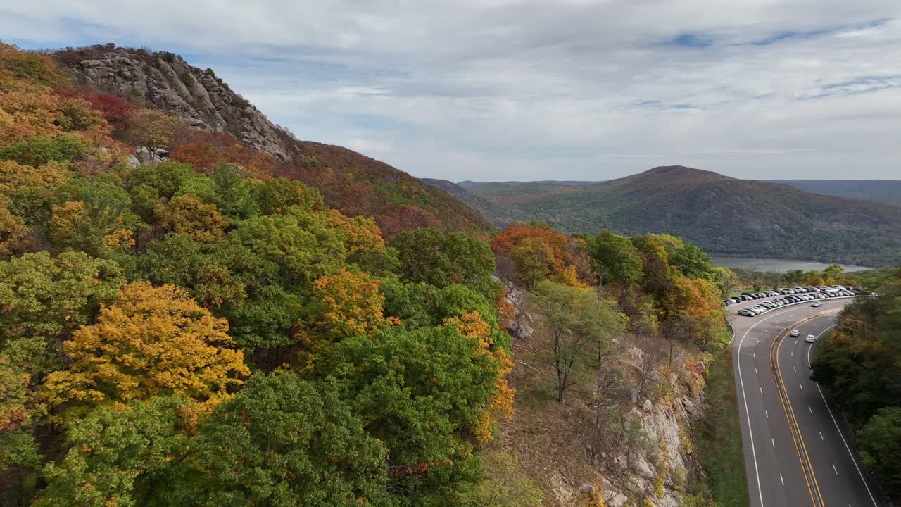 una vista aérea de las montañas en el norte del estado de nueva york durante el cambio de follaje de otoño, en un hermoso día con nubes blancas