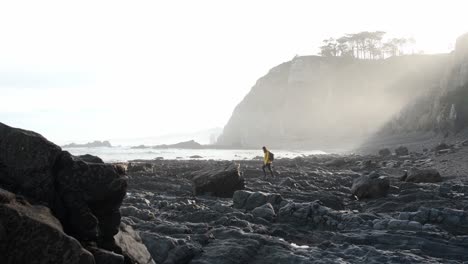 viajera caminando por la costa rocosa rodeada de acantilados afilados