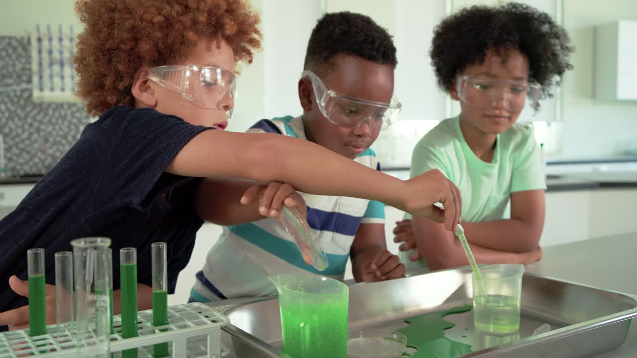 African American preteen boys with goggles in lab, seeing green gel pouring stirring observing mix