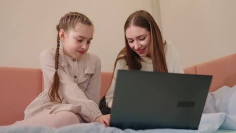 madre e hija usando la computadora portátil juntos