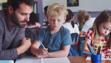 Grundschullehrer-Gibt-Männlichen-Schülern-Eins-Zu-Eins-Unterstützung-Im-Klassenzimmer