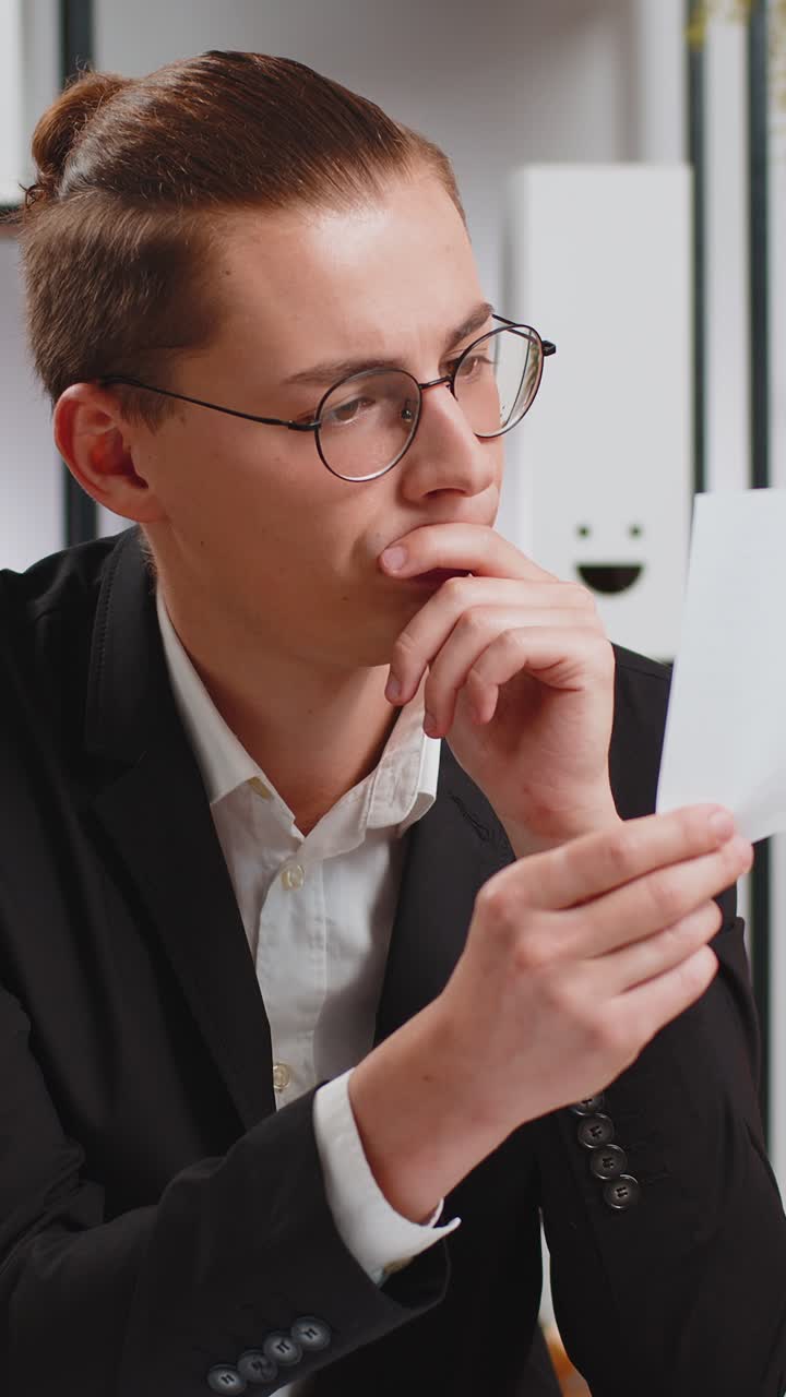 Serious businessman sitting at home office desk with letter reading bad news upset and disappointed