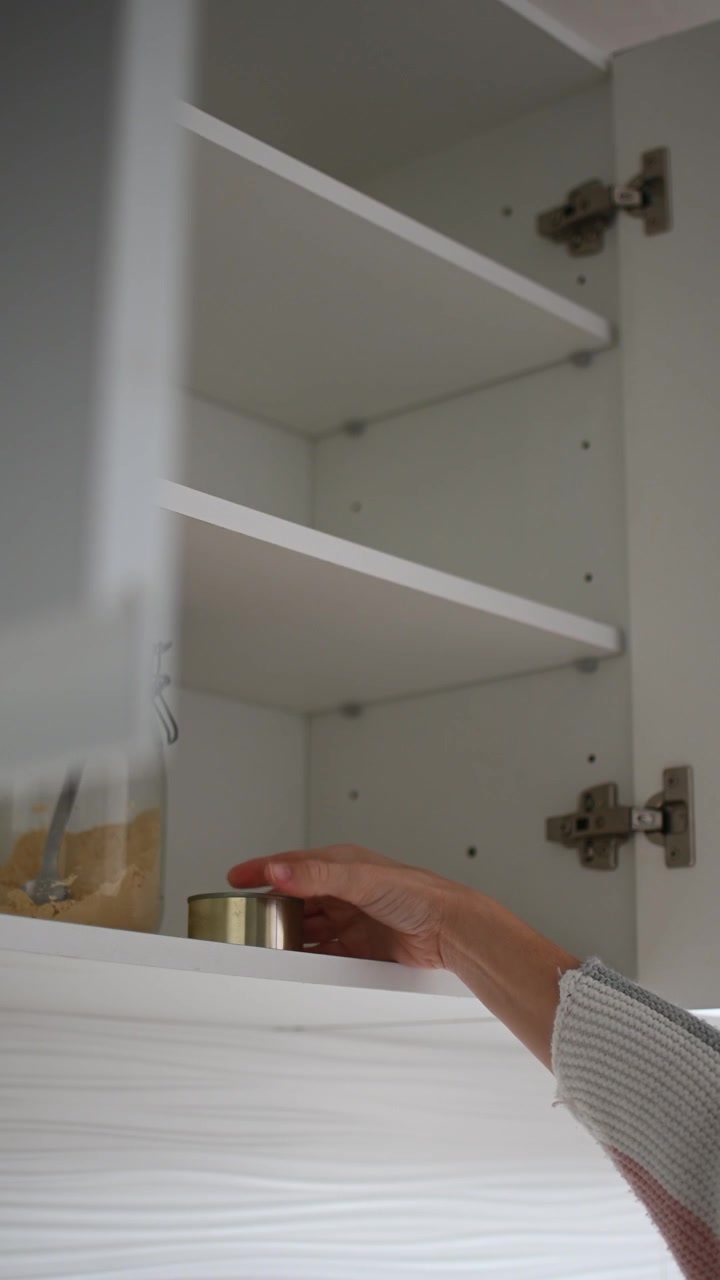 Neredeyse boş bir kileri açan kadın, gıda kıtlığı ve enflasyon konsepti.