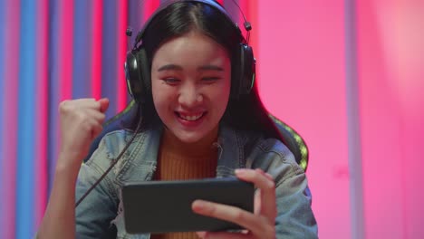 excited girl gamer celebrates victory while playing game on mobile phone