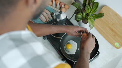 person cooking fried eggs