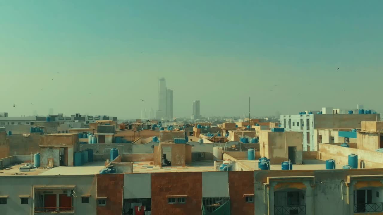 Aerial Over Rooftops With View Of Bahria Icon Tower In The Distance In Karachi. Pedestal Up