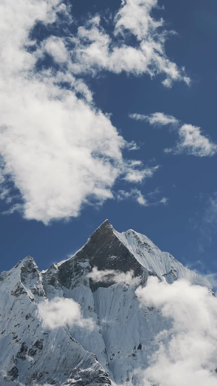 Snowcapped Mountains Summit in Clouds, Vertical Snowy Mountain Top Video for Social Media Instagram Reels and Tiktok of Snowy Himalayas Mountains Peaks in Snow in Nepal on Blue Sky Sunny Day