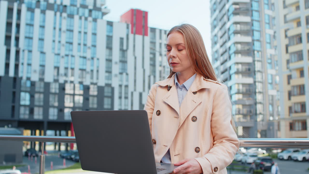 Happy mature caucasian businesswoman lady closing laptop computer smiling in downtown city street