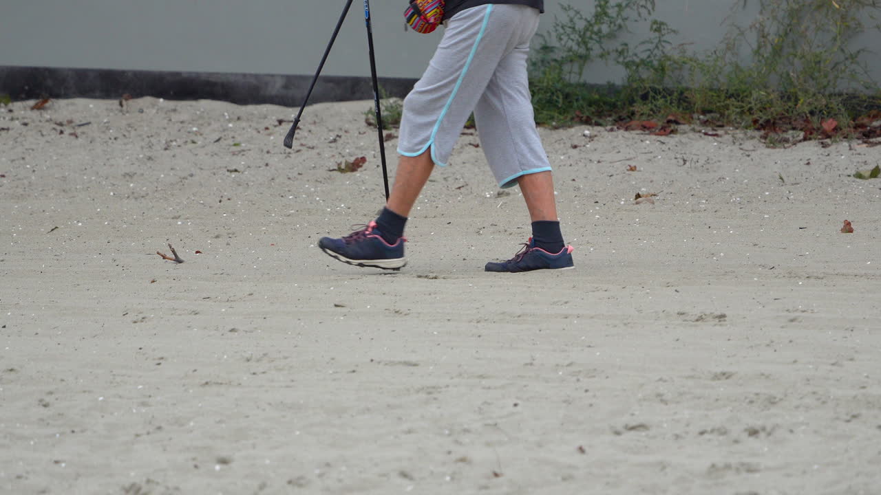 movimiento lento 4k de una persona caminando en una playa de arena blanca, la mitad inferior
