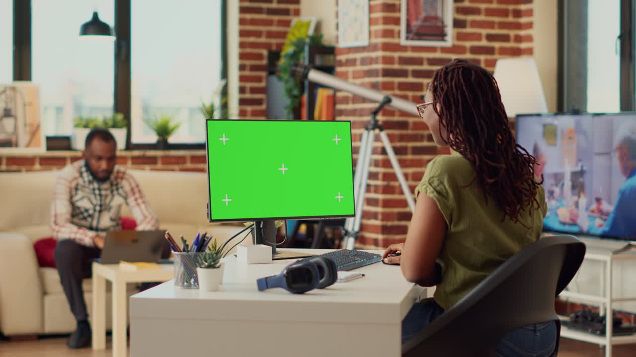 Female freelancer using computer with greenscreen