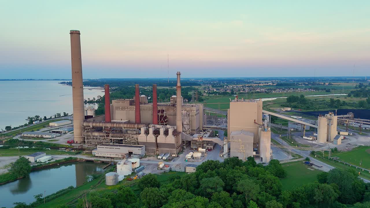 Drone video of Walleye Bay Shore Power Plant beside Lake Erie with pink sky in Oregon, Ohio