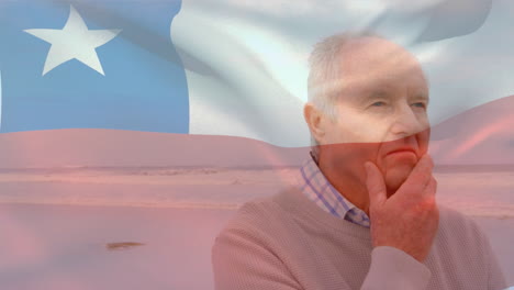 animation of flag of chile over thoughtful senior caucasian man on beach