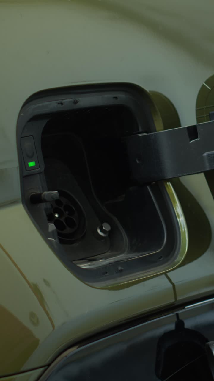 Vertical video Close up of driver recharging green technology EV automobile battery