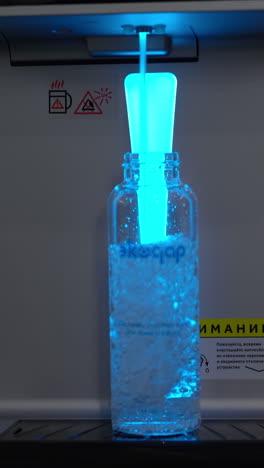 blue light water dispenser filling a bottle