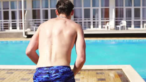 Rückansicht-Des-Jungen-Athletischen-Mannes-In-Badeshorts,-Der-Läuft-Und-Zum-Schwimmbad-Springt