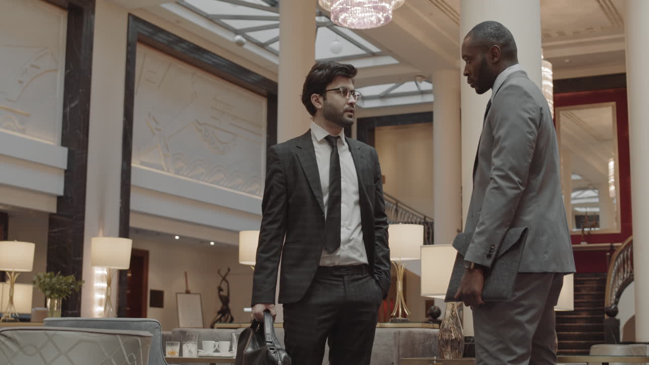 Businessmen Shaking Hands in Hotel Lobby