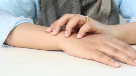 young women suffering from itching skin sitting on park ,