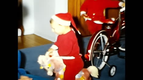 toddler sitting on toy horse in room. circa usa - 1970s: a toddler can be seen sitting on a toy horse in a room during the 1970s in the usa.