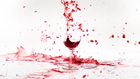 breaking the glass of red wine in slow motion on white background