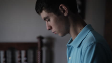 Closeup-of-the-face-of-a-young-man,-teenage-boy,-high-school-student,-packing-back-pack