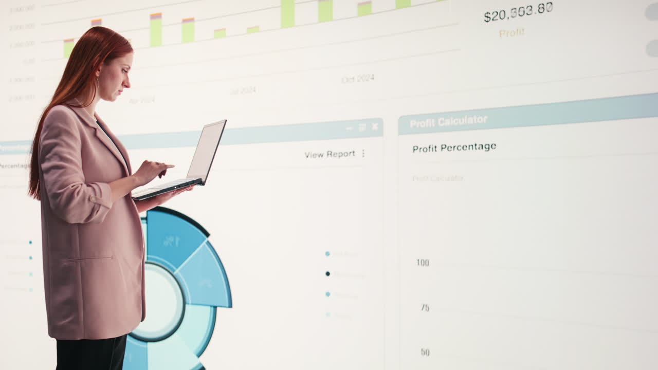 Businesswoman Analyzing Financial Data on Laptop and Large Screen