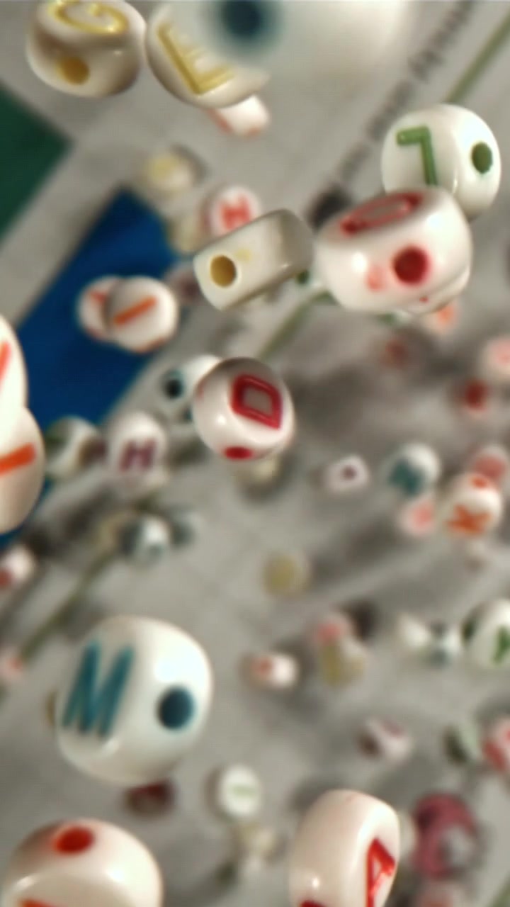 Perline colorate con lettere dell'alfabeto che cadono al rallentatore