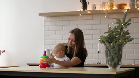 toddler with mom playing with the toy in nursery room. mother with her 1 year-old baby boy having fun at home