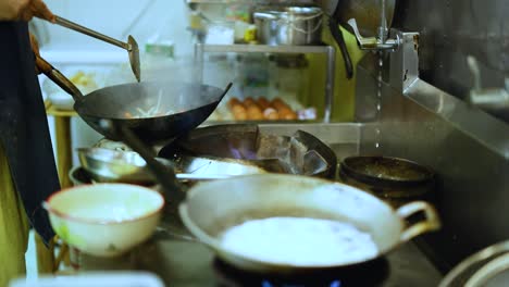 chef skillfully cooks with a wok in kitchen