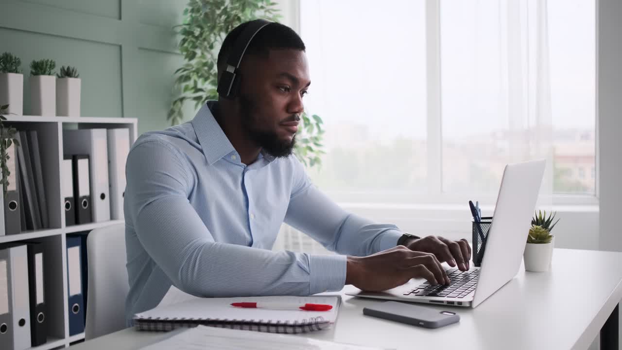 African American businessman listening music and having fun while working