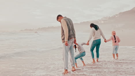 Family,-holding-hands-and-play-in-beach-water