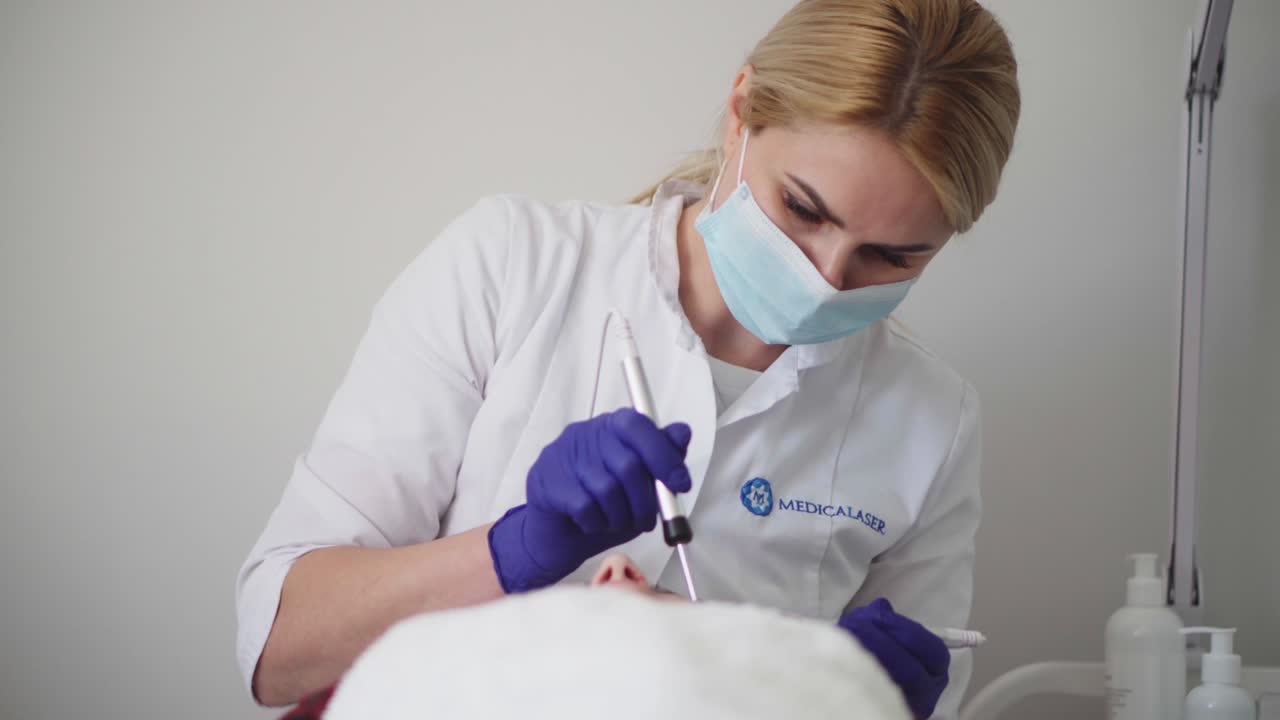 procedimiento de hardware en cosmetología. el cosmetólogo suaviza las arrugas con microcorrientes. peeling, fonoforesis, masaje y lifting facial en una clínica de belleza.