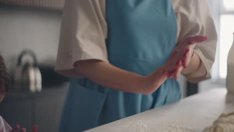 woman and child girl are cooking in home kitchen mother and daughter are dusting hands from flour