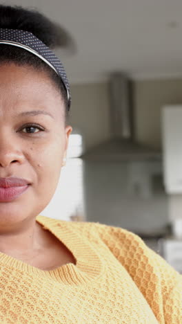 vertical video of portrait of happy african american woman smiling to camera, in slow motion