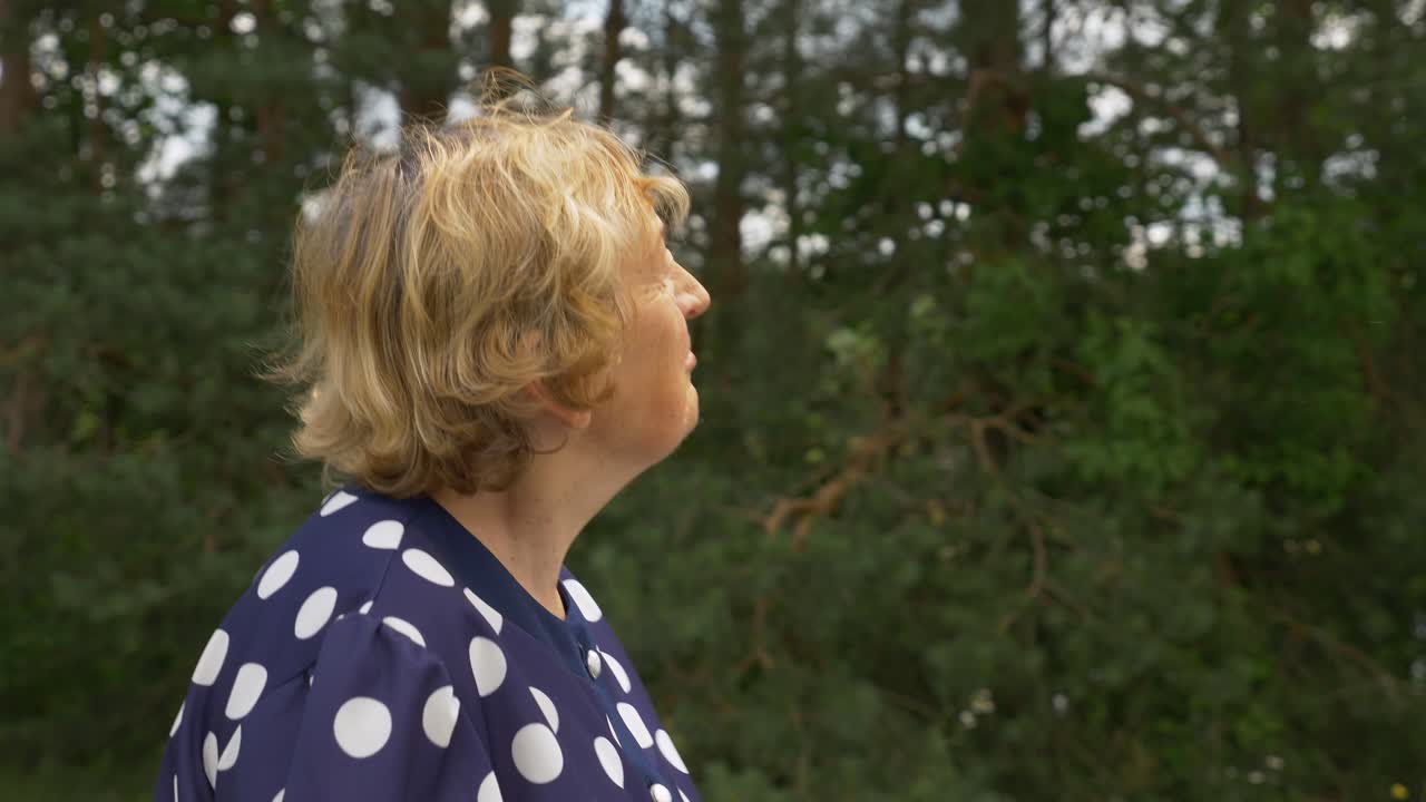 anciana feliz caminando y mirando los alrededores, sonriendo con los ojos, pensando en el pasado