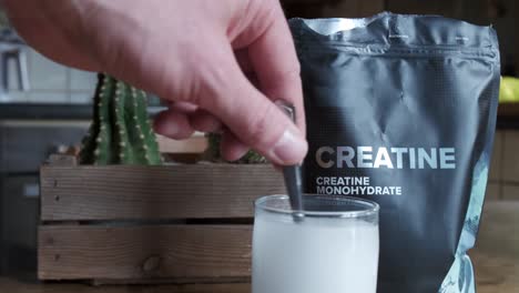 close up of a hand mixing creatine monohydrate in a glass 4k slow motion