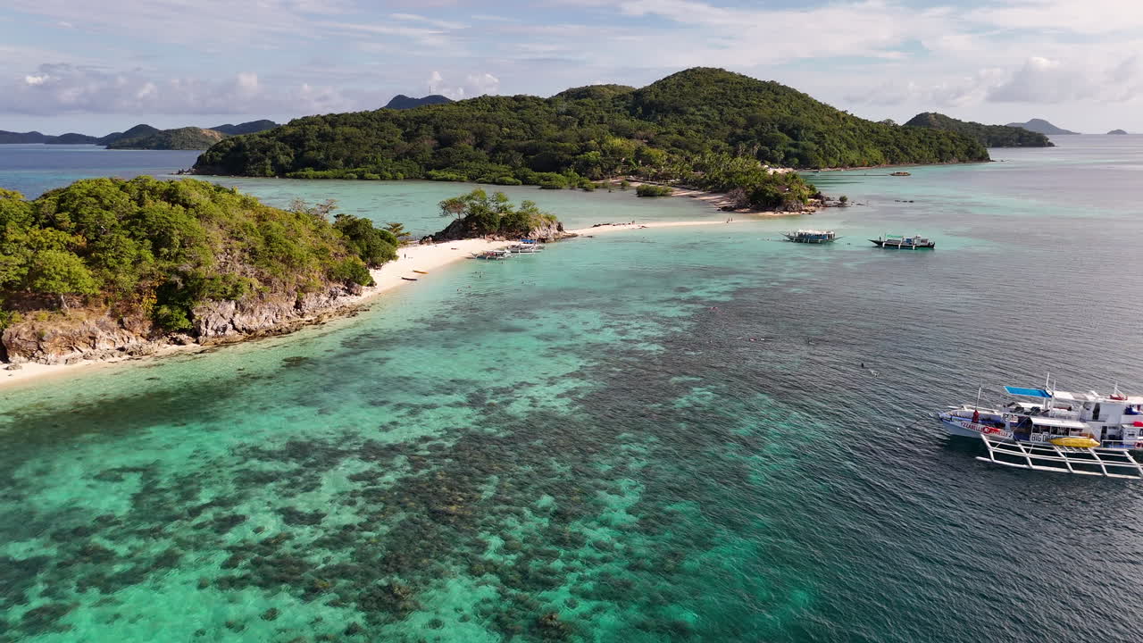 Aerial drone view of Coron Island’s dramatic cliffs, tropical greenery, and idyllic turquoise waters, Philippines. Revealing shot with b