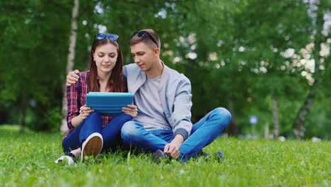 Junges-Mädchen-Und-Ein-Mann-Benutzten-Ein-Tablet-Im-Park-Junge-Umarmt-Mädchen-HD-Video