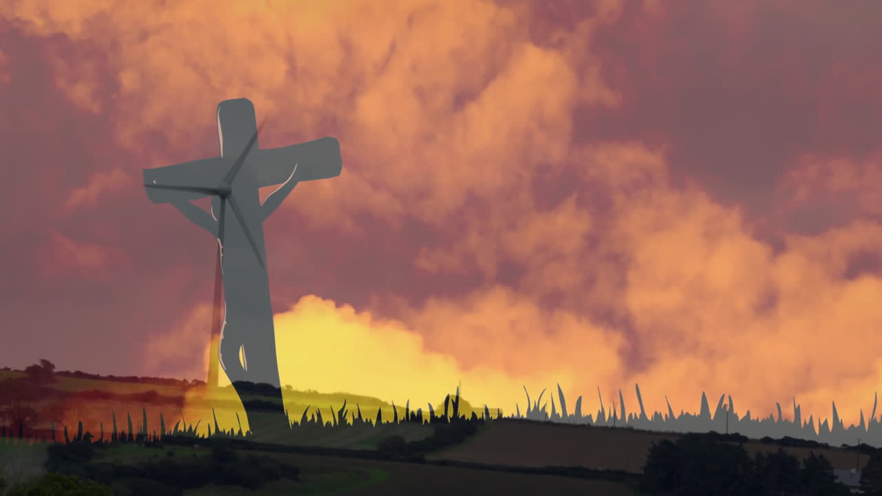 Vibrant sunset sky with silhouette of cross over grassy landscape