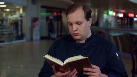 Chef reading a book in a mall