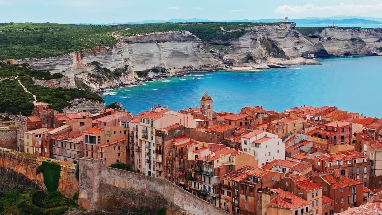 Aerial drone shot over the historic coastal town of Bonifacio in Corsica, France. High view of the rocky steep cliff and the turquoise sea. Ancient Citadel overlooking the rugged coastline