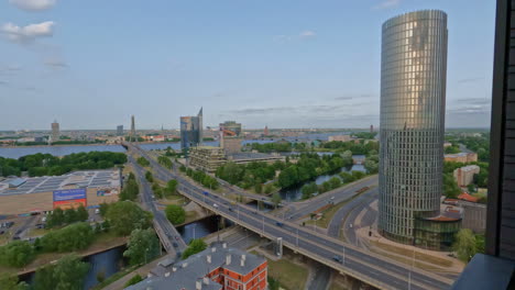 a smooth reveal shot of a cityscape by a river with skyscrapers in riga - latvia