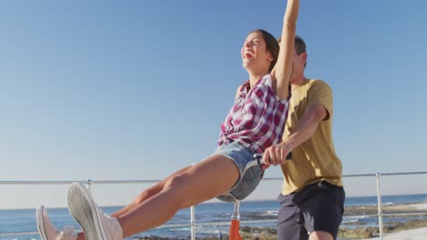 una joven pareja de adultos relajándose en la orilla del mar