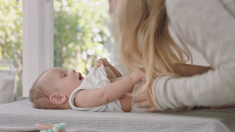 szczęśliwa matka opiekująca się dzieckiem w domu kochająca mama delikatnie całująca małe dziecko uspokajająca swoje dziecko ciesząca się macierzyństwem