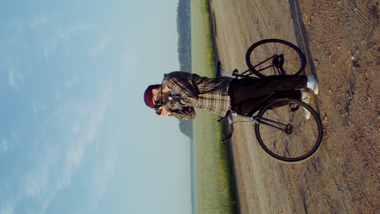 fotógrafo en una bicicleta de engranajes fijos en un campo rural
