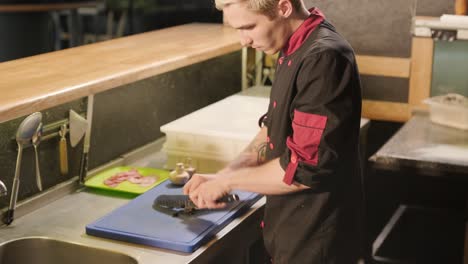 man cooking pizza in the kitchen of restaurant